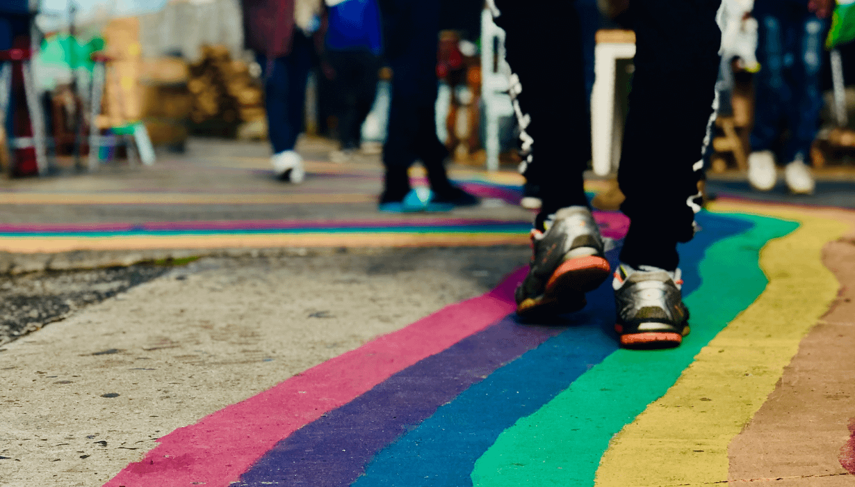 Person walking down a rainbow pavement