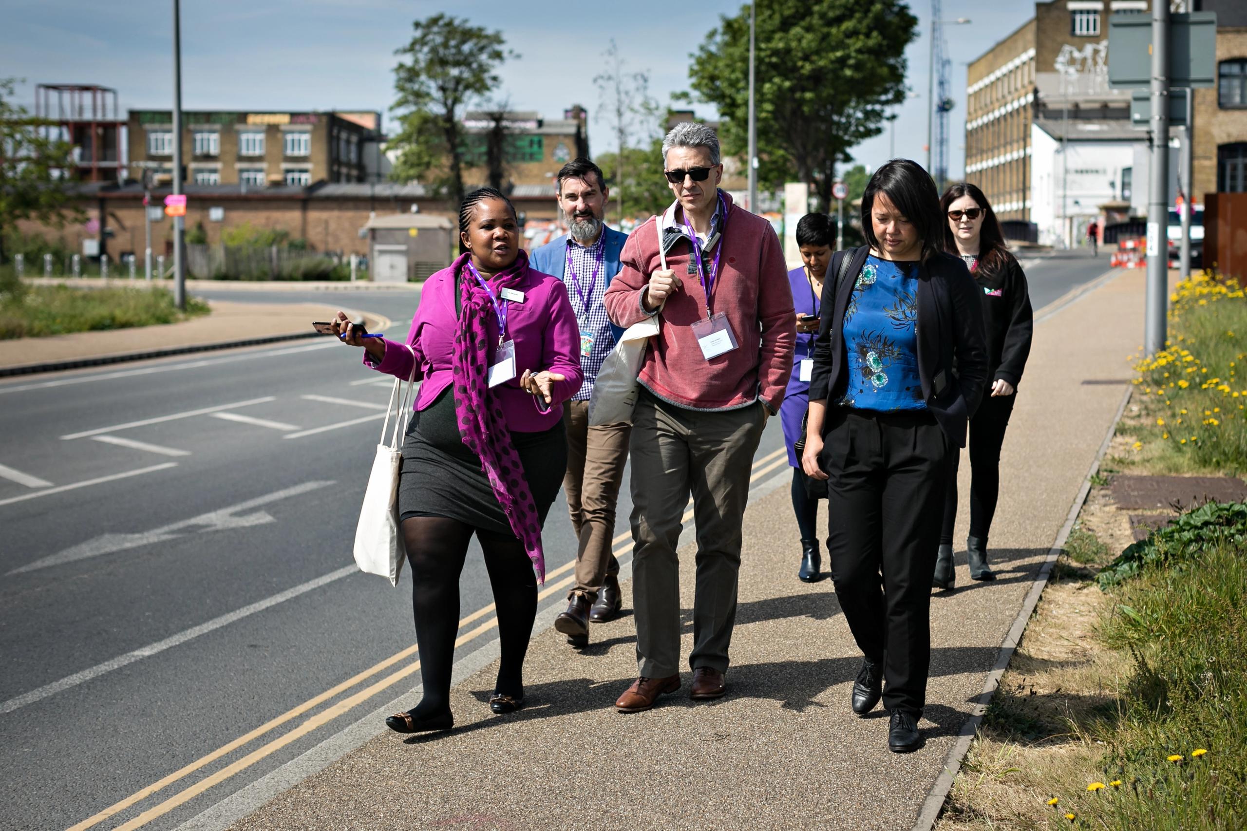 A group of people walking on a pavement