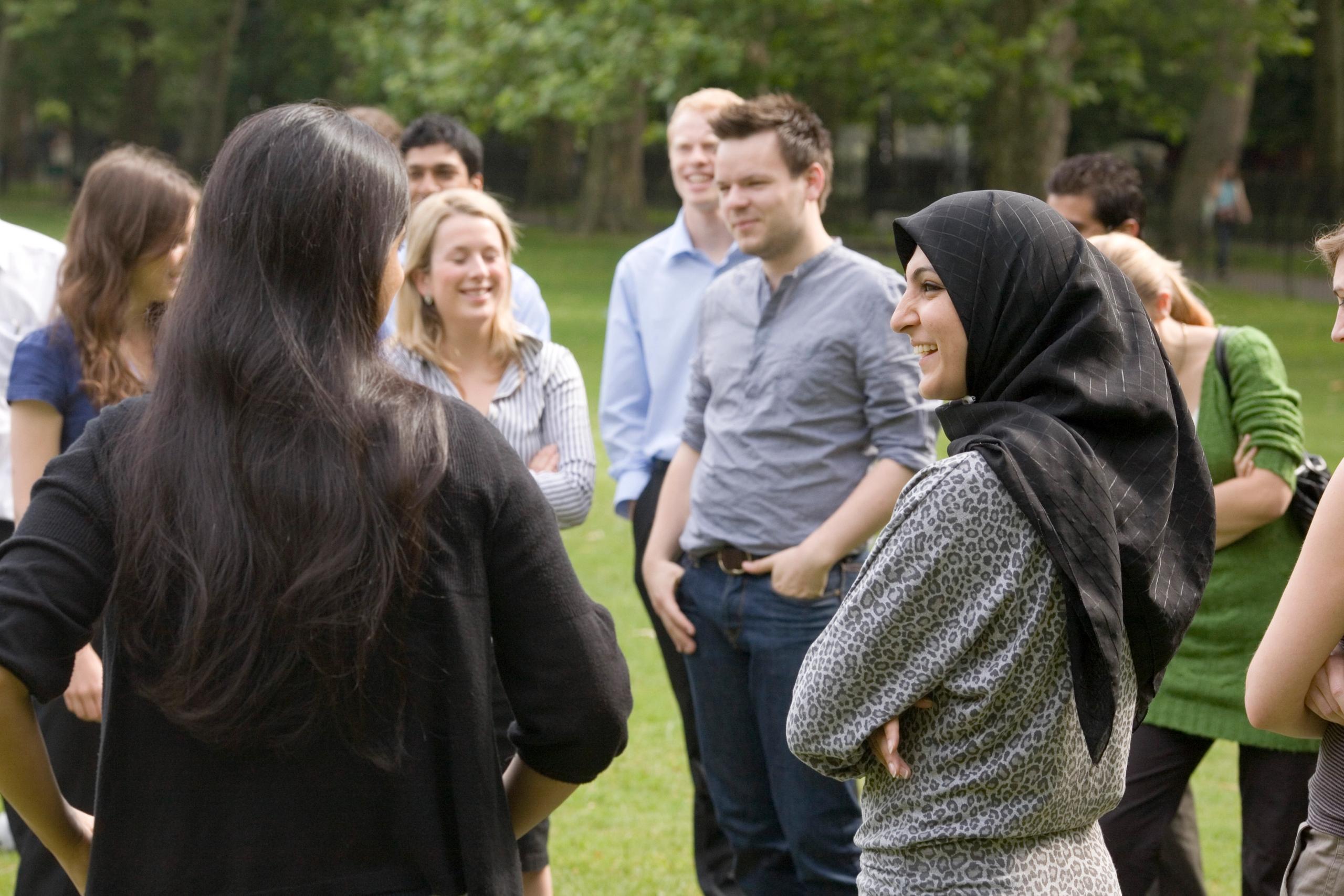A group of young people in conversation outdoors