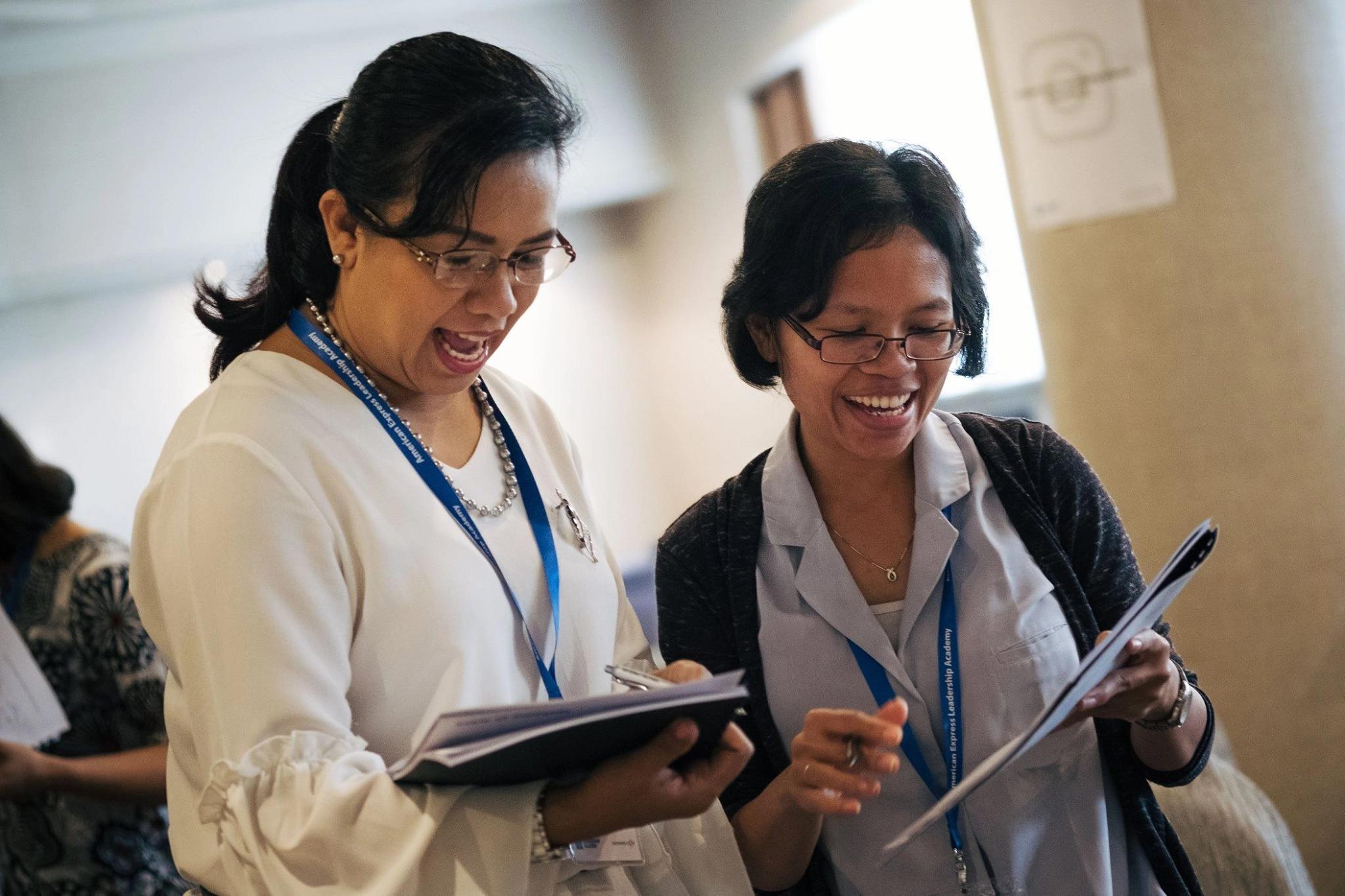 Close up of two women smiling and looking at a document