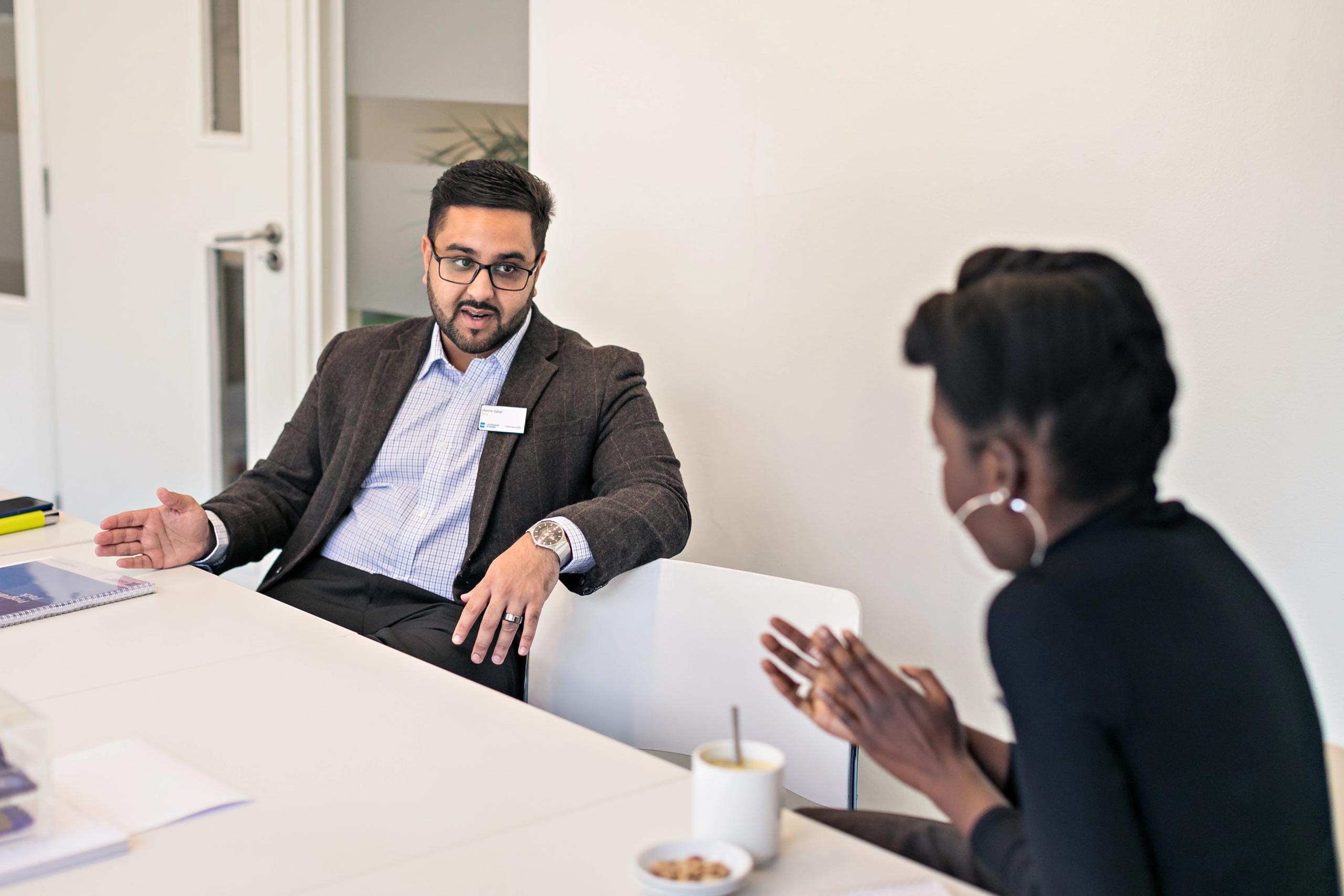 Two people seated at a table in conversation