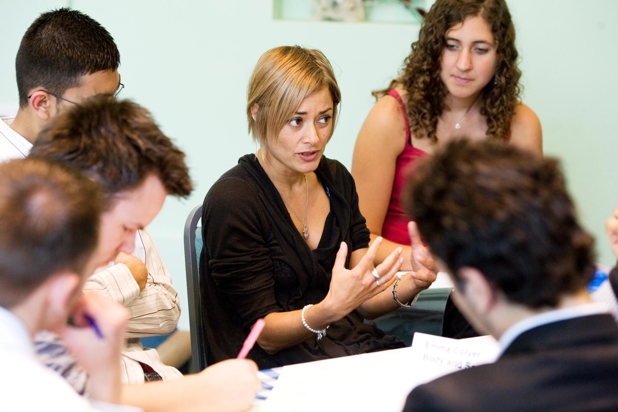 Young woman talking to a group of people