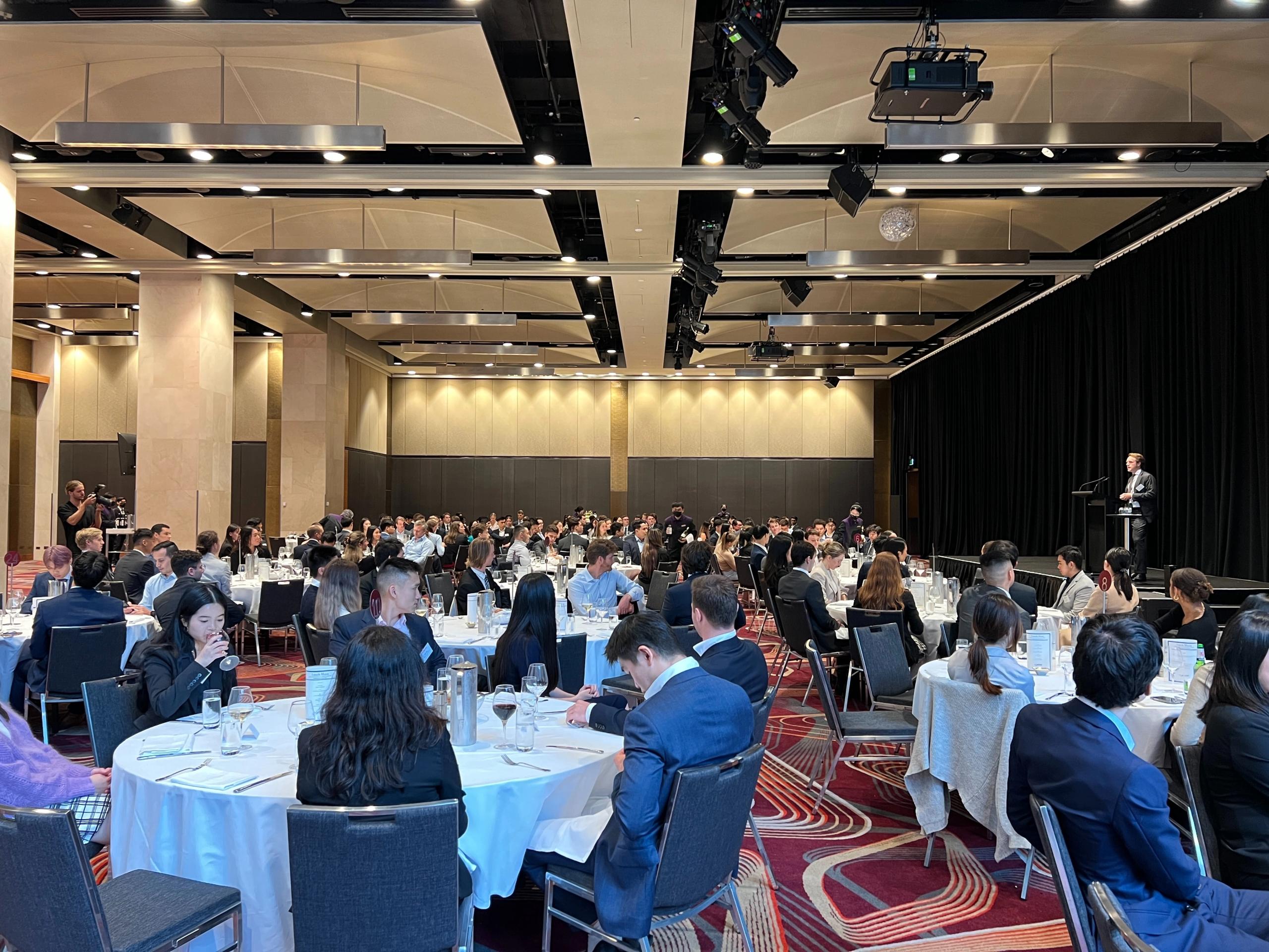 A group of people seated at a conference facing the speaker